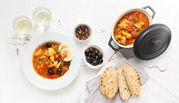 Cocido en una olla y un plato acompañado de pan tostado