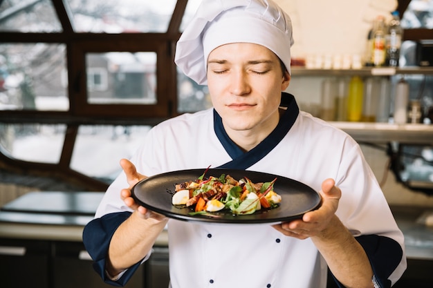 Foto gratuita cocinar la ensalada que huele con carne en un plato