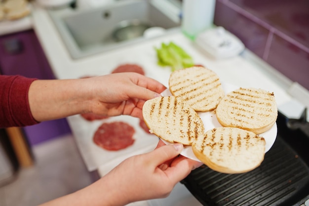 Cocinar hamburguesas en la cocina de casa durante el tiempo de cuarentena