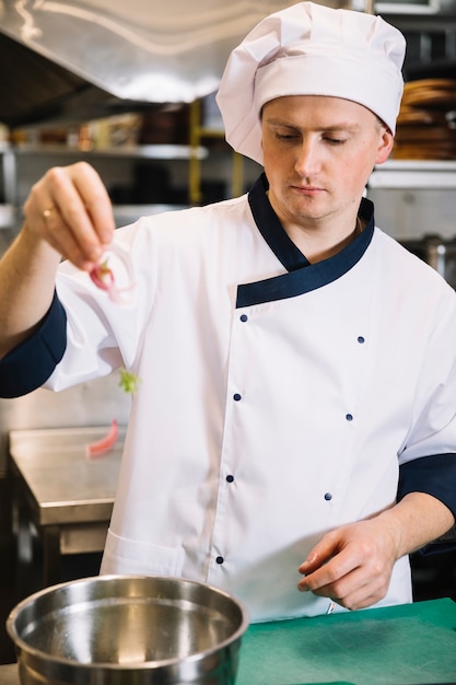 Cocinar poniendo las verduras en un bol para la ensalada