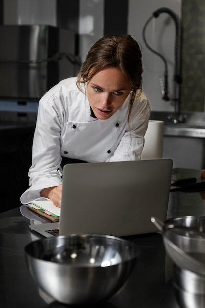 Cocinera en la cocina usando un dispositivo portátil