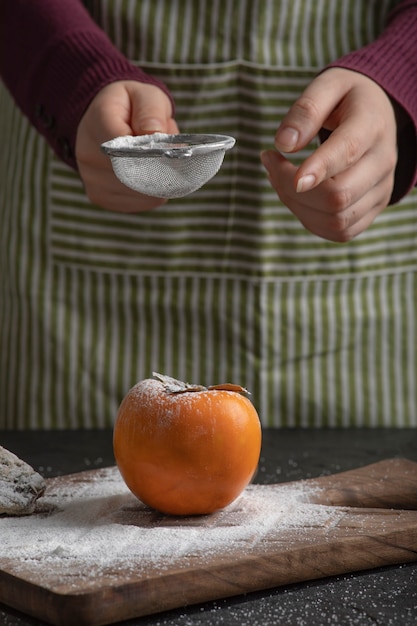 Cocinera derramar harina de caqui dulce en la cocina