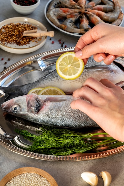 Foto gratuita cocinero de alto ángulo limpiando pescado en la cocina