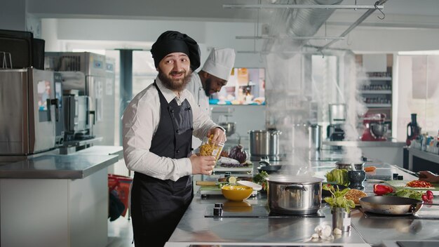 Cocinero auténtico haciendo lecciones de cocina en cámara en la cocina, preparando comida gourmet con receta culinaria. Hombre grabando preparaciones de platos en cámara para un programa de televisión gastronómico.