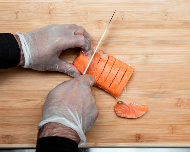 El cocinero corta el salmón en rodajas