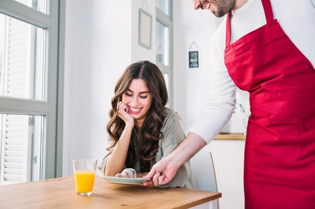 Cocinero dando croissant a su novia