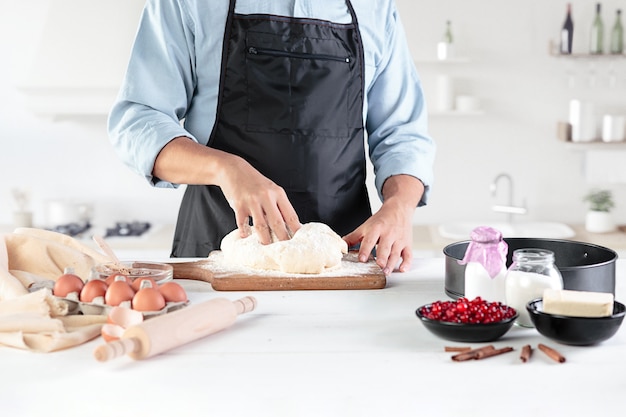 Un cocinero con huevos en una cocina rústica contra la pared de las manos de los hombres.