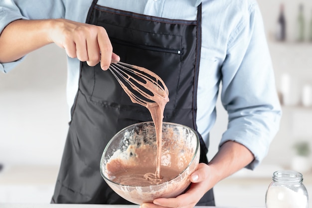 Un cocinero con huevos en una cocina rústica contra la pared de las manos de los hombres.