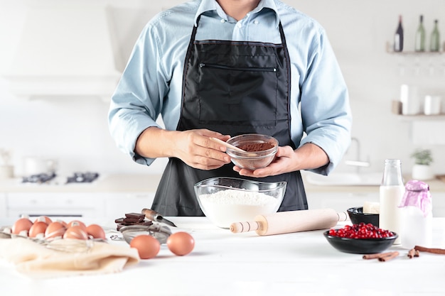 Un cocinero con huevos en una cocina rústica contra la pared de las manos de los hombres.