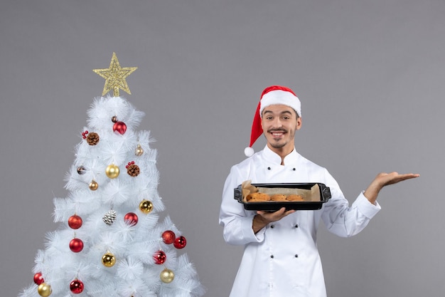 Cocinero joven expresivo posando para las vacaciones de invierno