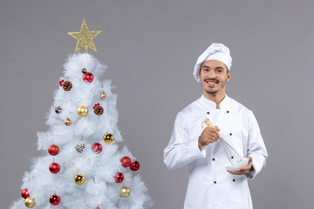 Cocinero joven expresivo posando para las vacaciones de invierno