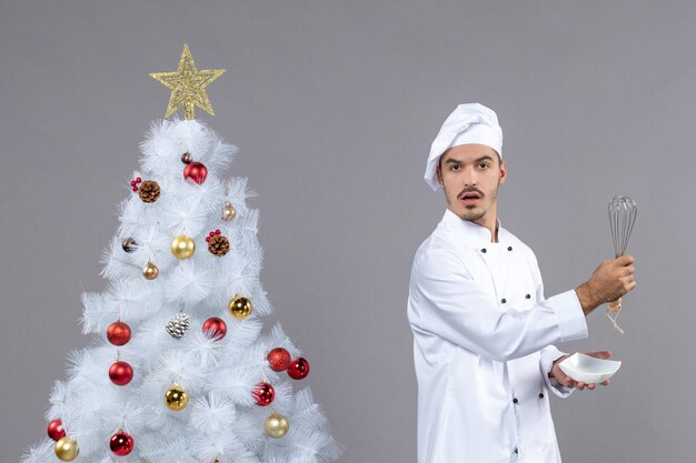 Cocinero joven expresivo posando para las vacaciones de invierno