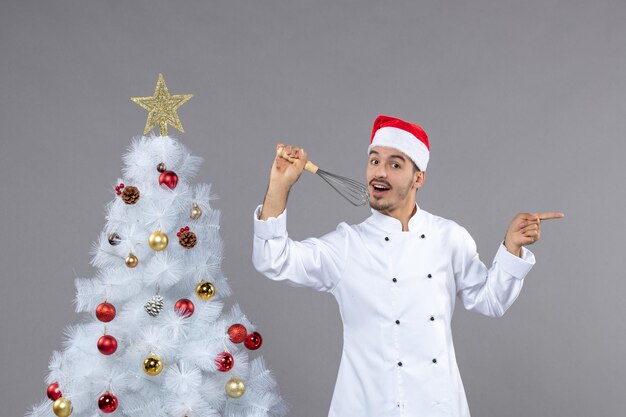 Cocinero joven expresivo posando para las vacaciones de invierno