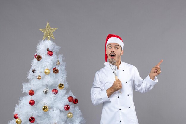 Cocinero joven expresivo posando para las vacaciones de invierno