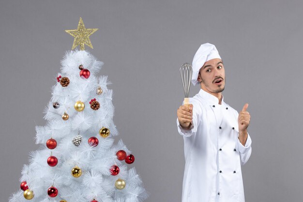 Cocinero joven expresivo posando para las vacaciones de invierno