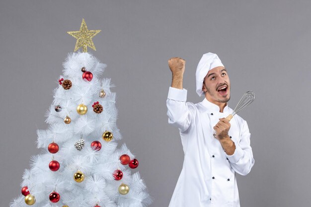 Cocinero joven expresivo posando para las vacaciones de invierno