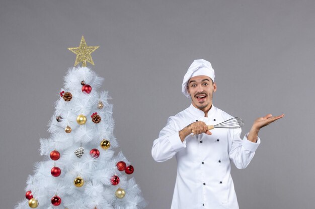 Cocinero joven expresivo posando para las vacaciones de invierno