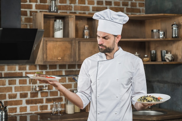 Foto gratuita cocinero de sexo masculino confundido mirando platos preparados
