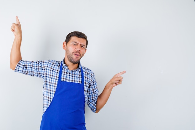 Foto gratuita cocinero de sexo masculino joven en un delantal azul y una camisa