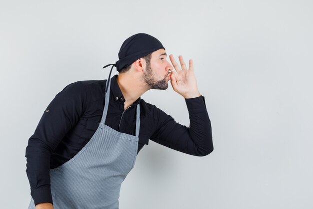 Cocinero de sexo masculino que muestra un gesto delicioso en camisa, vista frontal del delantal.