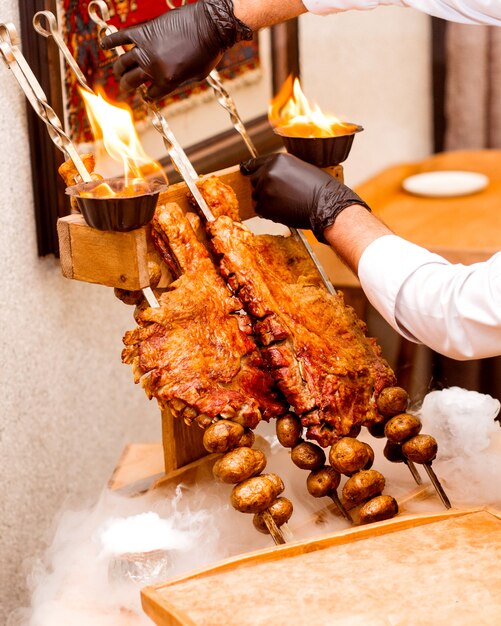 El cocinero sostiene costillas fritas y papas