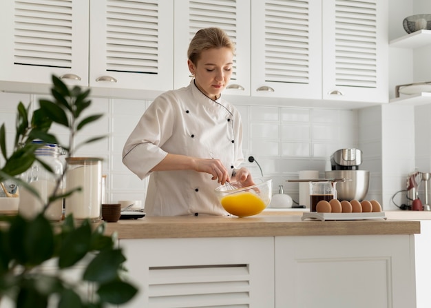 Cocinero de tiro medio revolviendo huevos