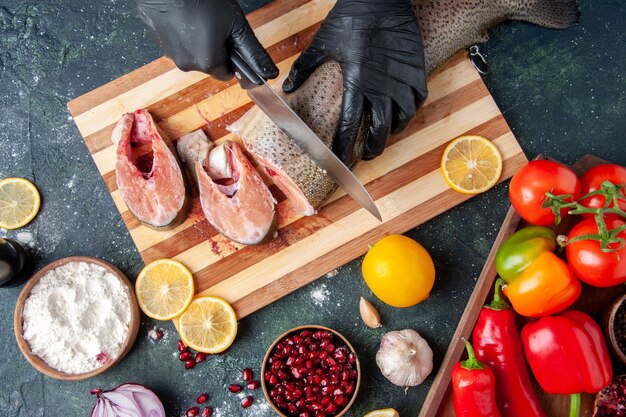 Cocinero de vista superior cortando pescado crudo en tazón de harina de tabla de cortar en la mesa