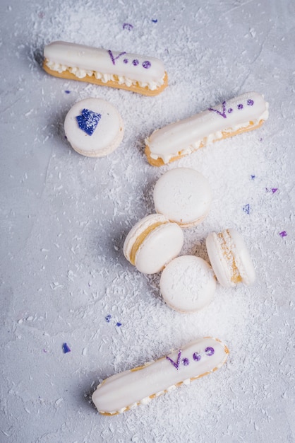 Foto gratuita coco desecado sobre macarrones al horno y eclairs