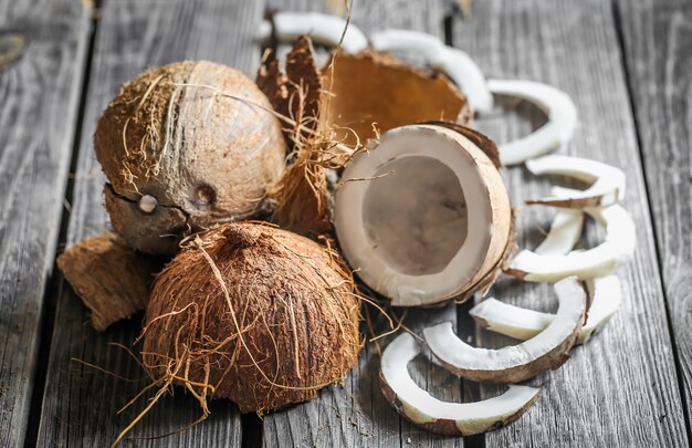 Cocos frescos rotos sobre mesa de madera