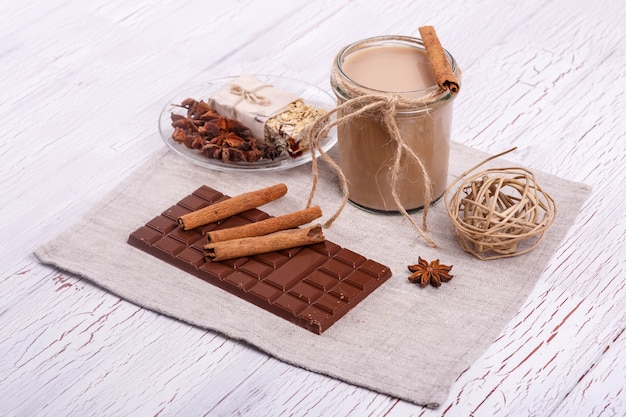Coctail de desintoxicación marrón con palitos de canela y chocolate se encuentran sobre la mesa