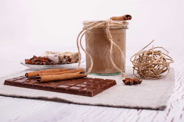 Coctail de desintoxicación marrón con palitos de canela y el chocolate se encuentran sobre la mesa