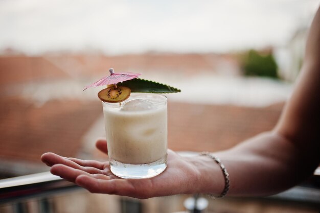 Cóctel alcohólico en vaso en mano de barman