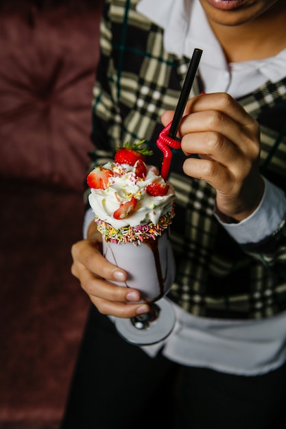 Cóctel de batido cubierto con crema batida y fresa