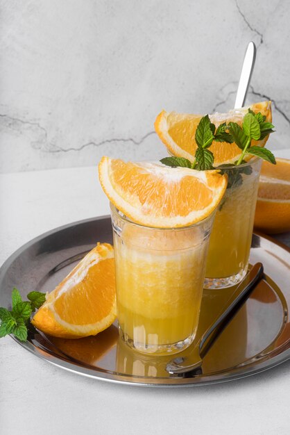 Cóctel de bebidas alcohólicas con naranja alta vista