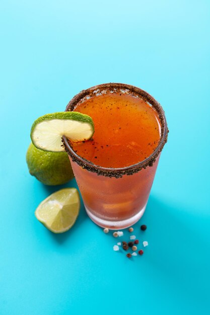 Cóctel casero de michelada con cerveza, jugo de lima, salsa picante, borde salado y jugo de tomate.