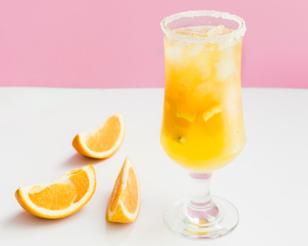 Cóctel frío de naranja tropical con hielo, fruta fresca.