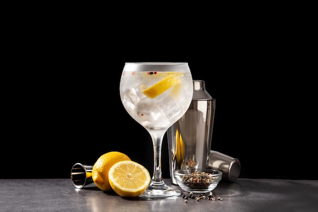 Cóctel de gin tonic en un vaso sobre fondo negro