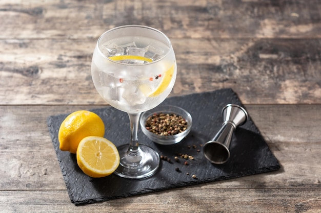 Foto gratuita cóctel de gin tonic en un vaso sobre una mesa de madera