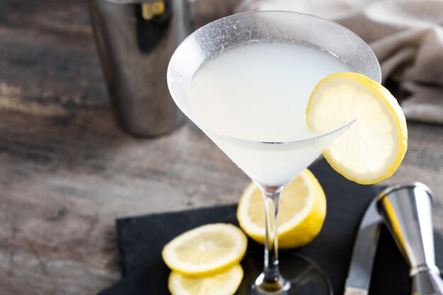 Cóctel de martini de gota de limón sobre piedra gris y fondo negro