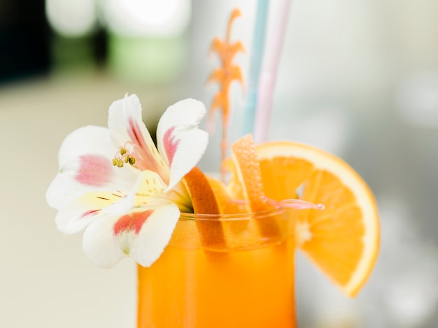 Cóctel de naranja con frutas decorado con orquídeas