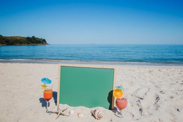 Cócteles y tablero verde en la playa