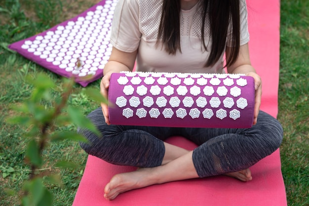 Foto gratuita colchoneta de masaje para relajación y tratamiento en manos femeninas en el jardín