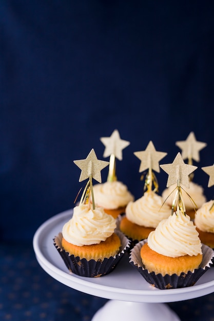 Colección de sabrosos pasteles con crema de mantequilla y estrellas en el stand.