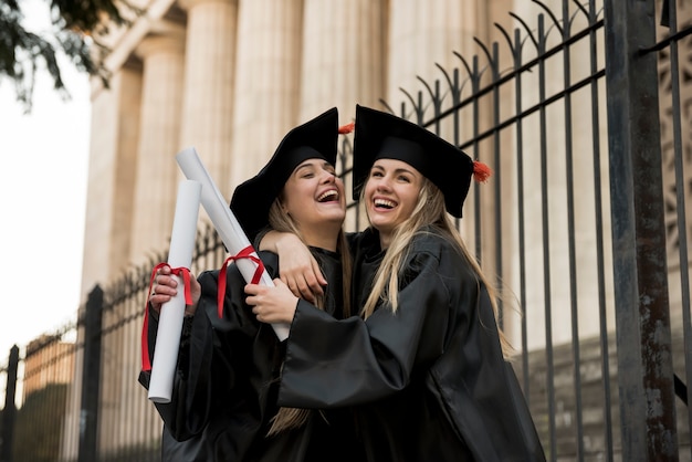 Colegas alegres graduandose de la universidad