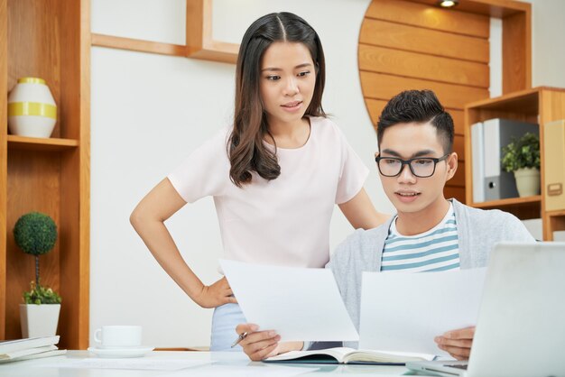 Colegas asiáticos que trabajan con papeles en la oficina