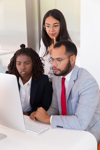 Colegas emocionados que usan la computadora juntos