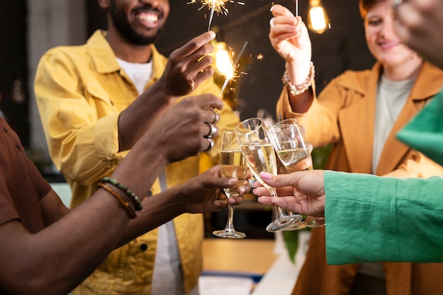 Colegas felices con fuegos artificiales de cerca