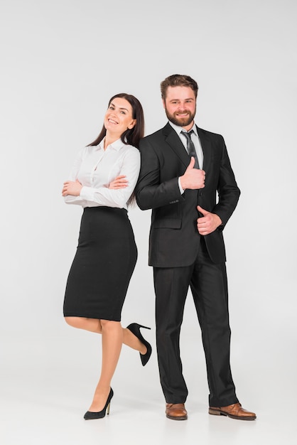 Colegas hombre y mujer apoyados unos en otros y sonriendo.