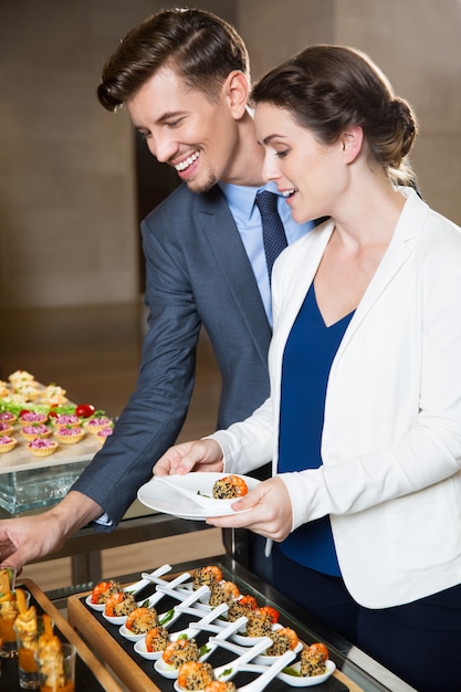 Los colegas de negocio para sí mismos en el buffet