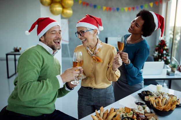 Colegas de negocios despreocupados divirtiéndose en la fiesta de Navidad en la oficina